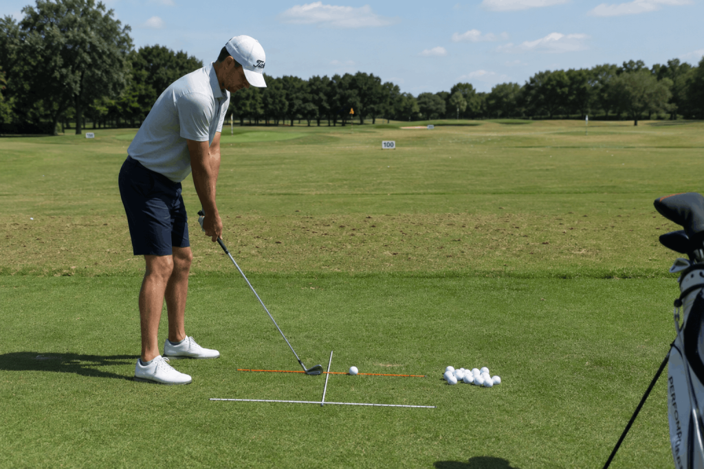 Golfer practicing setup alignment drill with training sticks