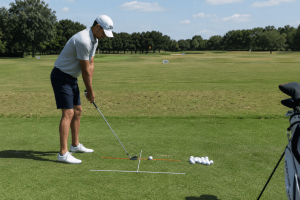 Golfer practicing setup alignment drill with training sticks